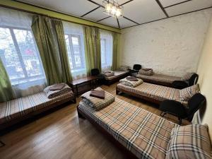 een woonkamer met 3 bedden en ramen bij Fox Hostel in Nikolayev