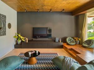 uma sala de estar com um sofá e uma televisão em Kidena House em Goa Velha