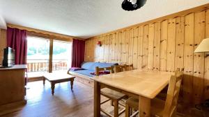 Zimmer mit Tisch und Bett in der Unterkunft Résidence Dame Blanche - Chalets pour 6 Personnes 054 in Narreyroux