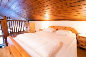 a large bed in a room with a wooden ceiling at Résidence Le Grand Vallon - LE GRAND VALLON - NO52GV MAE-3116 in Villarodin-Bourget