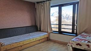 um quarto com uma cama e uma janela com montanhas em Résidence Pendine 1 - Appartements pour 4 Personnes 554 em Les Prés