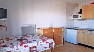 una piccola cucina con un letto in una camera di Résidence Pendine 1 - Appartements pour 4 Personnes 554 a Les Prés