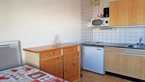 uma pequena cozinha com um lavatório e um micro-ondas em Résidence Pendine 1 - Appartements pour 4 Personnes 554 em Les Prés