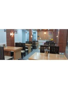 une salle à manger avec des tables et des chaises en bois dans l'établissement Hotel The Narendra Orchid, Phata, à Phata