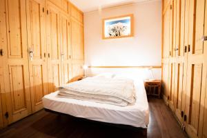 - une chambre avec un lit blanc et des placards en bois dans l'établissement Résidence Le Pra - 2 Pièces pour 6 Personnes 193118, à Villarodin-Bourget