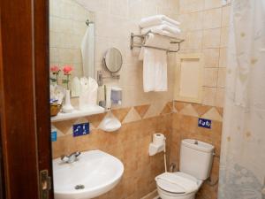 a bathroom with a toilet and a sink at Riyadh Al Deafah Hotel in Makkah