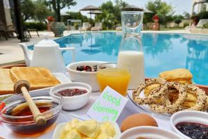 ein Frühstückstablett mit Frühstückszutaten und einer Flasche Milch in der Unterkunft Country Inn in Kallithea (Chalkidiki)