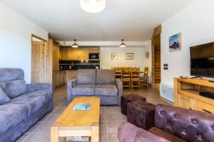 a living room with a couch and a table at Résidence LA GRANGE AUX FEES - Appartement GRANGE AUX FEES E04 pour 8 Personnes in Valmorel