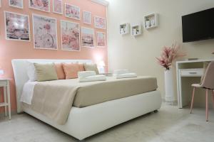 a bedroom with a white bed with pink walls at B&B Colors in Lesina