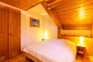 ein Schlafzimmer mit Holzdecken und einem Bett mit zwei Lampen in der Unterkunft Résidence Les Fermes du Soleil - maeva Home - Appartement 3 pièces 5 personnes - Sélection MAE-9504 in Les Carroz d'Araches + 20 Fotos