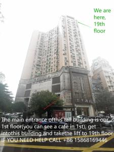 un grand bâtiment avec un panneau devant lui dans l'établissement Yootel Hostel, à Hangzhou