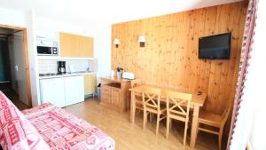 una cucina e una sala da pranzo con un tavolo e una televisione di Résidence Parc Aux Etoiles - C302PAE - APPARTEMENT 2 CHAMBRES AVEC BALCON MAE-8834 a Narreyroux