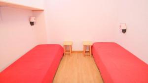 una stanza con due letti rossi e due sedie di Résidence Parc Aux Etoiles - C302PAE - APPARTEMENT 2 CHAMBRES AVEC BALCON MAE-8834 a Narreyroux Altre 5 foto