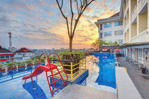 a swimming pool with a slide at a hotel at Grand Zuri Malioboro in Yogyakarta