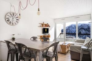 a living room with a table and chairs and a clock at Résidence Le Christiana - maeva Home - Appartement 2 pièces 6 personnes - 614 in Orcières