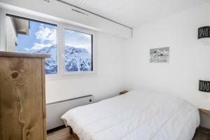 una camera con letto e finestra con montagna innevata di Résidence Le Christiana - maeva Home - Appartement 2 pièces 6 personnes - 614 a Orcières