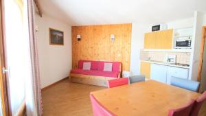 a small room with a table and a kitchen at Résidence Parc Aux Etoiles - Appartements pour 6 Personnes 794 in Narreyroux