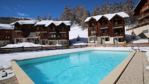 a swimming pool in the snow in front of a hotel at Résidence Parc Aux Etoiles - Appartements pour 6 Personnes 794 in Narreyroux