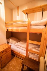 two bunk beds in a room with a desk at Résidence Le Grand Vallon - Studio pour 4 Personnes 193157 in Villarodin-Bourget