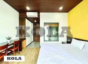 een hotelkamer met een bed en een eetkamer bij Kola Apartments in Ho Chi Minh-stad