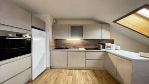 una cucina con armadi bianchi e un apparecchio nero di Résidence Parc Aux Etoiles - C505PAE - APPARTEMENT SPACIEUX 3 CHAMBRES, BALCON MAE-8844 a Narreyroux Altre 4 foto