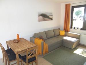 ein Wohnzimmer mit einem Sofa und einem Tisch in der Unterkunft Ferienquartier Kronenfeld in Zinnowitz