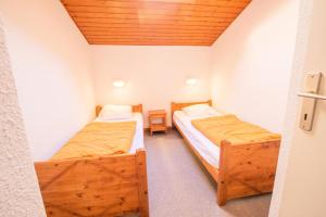 - 2 lits dans une petite chambre dotée de plafonds en bois dans l'établissement Résidence Les Arolles - LES AROLLES - AR17A MAE-3149, à Villarodin-Bourget