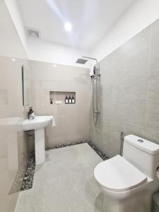 a white bathroom with a toilet and a sink at 148 Guesthouse and Resort in Alaminos +70 photos