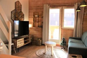 a living room with a blue couch and a tv at BOURG MOREL G - Duplex Le Bourg Morel 3 - 1 pour 8 Personnes 26 in Valmorel