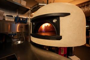 a pizza oven in a kitchen with a fire in it at The Hive at Poppi-Red in Hawkshead