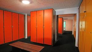 an empty locker room with orange lockers and a table at Résidence Cortina 1 - Appartements pour 4 Personnes 914 in Les Prés