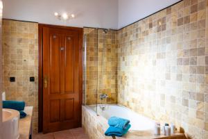 baño con bañera y ducha con toallas azules en Natursteinfinca mit Meerblick & Pool, en Porto Cristo