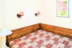 a bed in a room with two lamps on the wall at Résidence Quartier Falaise - maeva Home - Appartement 2 pièces 6 personnes - Sélection MAE-2824 in Avoriaz