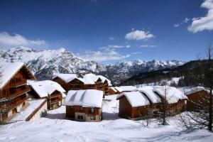 un gruppo di edifici ricoperti di neve con montagne di Résidence Parc Aux Etoiles - C103PAE - APPARTEMENT 2 CHAMBRES AVEC BALCON MAE-9064 a Narreyroux