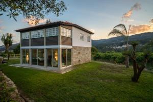 a house with a large window on a lawn at Casa da Vinha in Arcos de Valdevez