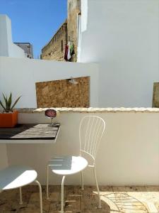 a white chair and a table on a balcony at Vejerísimo Casa Boutique in Vejer de la Frontera