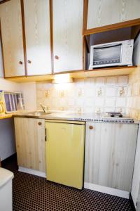 uma cozinha com um frigorífico amarelo e um micro-ondas em Résidence Les Portes De La Vanoise - 2 Pièces pour 6 Personnes 193184 em Villarodin-Bourget
