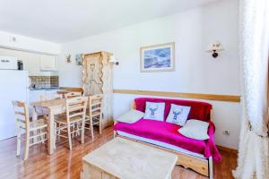 een woonkamer met een rode bank en een tafel bij Résidence Le Hameau Du Puy - maeva Home - Appartement 3 pièces 4 personnes 774 in Superdevoluy