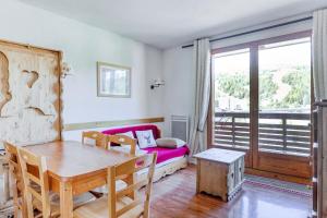 a living room with a table and a couch at Résidence Le Hameau Du Puy - maeva Home - Appartement 3 pièces 4 personnes 774 in Superdevoluy