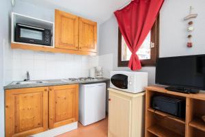 a small kitchen with a sink and a microwave at Résidence Les Balcons De La Vanoise - 2 Pièces pour 6 Personnes 193186 in Villarodin-Bourget