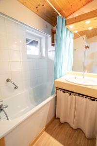 een badkamer met een bad en een wastafel bij Résidence Les Portes De La Vanoise - 2 Pièces pour 6 Personnes 193188 in Villarodin-Bourget