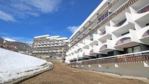 a large white building with snow in front of it at Résidence Cortina 2 - Appartements pour 6 Personnes 884 in Les Prés