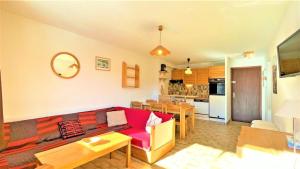 sala de estar con sofá rojo y cocina en Résidence Les Soldanelles - Appartements pour 6 Personnes 134 en Puy-Saint-Vincent