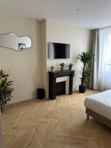 a living room with a fireplace and a tv on a wall at Les Chambres du Faubourg in Paris