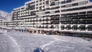 a large building with snow on the ground in front of it at Résidence Pendine 2 - Appartements pour 4 Personnes 974 in Les Prés