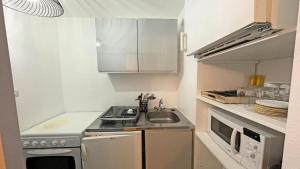 a small kitchen with a sink and a stove at Résidence Cortina 1 - Appartements pour 6 Personnes 974 in Les Prés