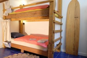 drewnianym łóżkiem piętrowym z drabiną w pokoju w obiekcie JOYU SURF SHACK w mieście Bidart