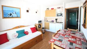 une chambre avec un canapé et une table dans une cuisine dans l'établissement Résidence Parc Aux Etoiles - Appartements pour 4 Personnes 024, à Narreyroux