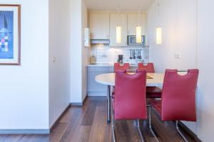 a kitchen with a table and red chairs at Haus Atlantic, FeWo 605 in Döse