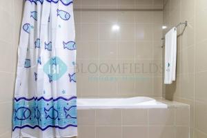 uma casa de banho com uma cortina de chuveiro e uma banheira em Relaxing 2 Bedrooms In Rak em Abu Dhabi